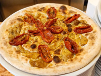 Weiße Pizza mit getrockneten Tomaten und Steinpilzen