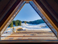 Fenster des Zimmers mit Blick auf die Terrasse und die Skipisten