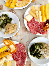 Pasta dish and cheeses with side dishes