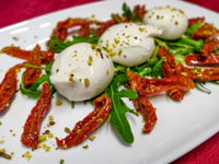Mozzarella with dried tomatoes and chopped pistachio