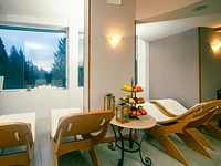 Entspannungsbereich mit Blick auf den Wald im Spa