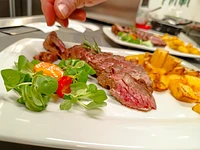 In Scheiben geschnittenes piemontesisches Fassona-Rindfleisch mit Ofenkartoffeln