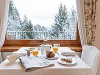Sanftes Erwachen mit Blick auf die weiß getünchten Wälder
