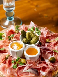 Platte mit lokalen Wurstwaren und Gurken
