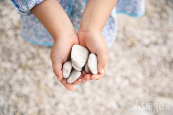 Bambina tiene in mano dei sassi Bambina tiene in mano dei sassi