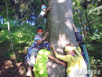 Bambini abbracciano un albero e ascoltano il bosco Bambini abbracciano un albero e ascoltano il bosco