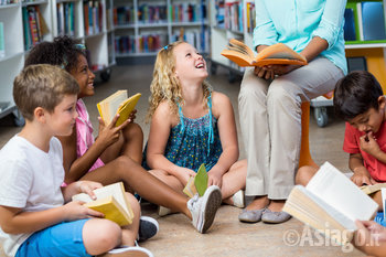 Bambini in cerchio ascoltano leggere una storia 