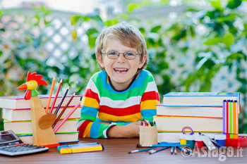 Bambino divertito tra libri e colori