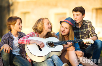 Gruppo di ragazzi si diverte suonando la chitarra