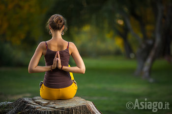 Donna seduta di spalle in posizione yoga Donna seduta di spalle in posizione yoga
