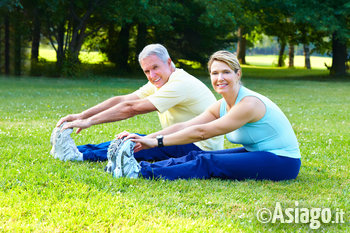 Uomo e donna che fanno stretching all'aria aperta