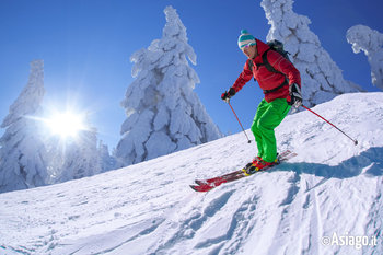 Sciatore sfreccia in discesa sulle piste innevate